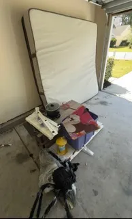 After: garage full of junk including a hot tub cover removed by Moose Junk Removal